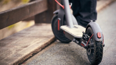 Electric scooter stands on a bridge in the street.